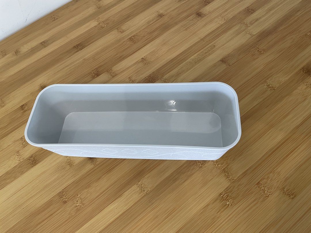 White rectangular storage container with textured pattern (Category: Storage Boxes & Baskets) located in Singapore. Submitted by lgemc (Listing ID 1451411737, Image 1). Description: - White rectangular storage container - Textured pattern on sides - Lighter grey interior - Ideal for organizing small items - Suitable for desk or drawer use - Approximately 10 inches in length.