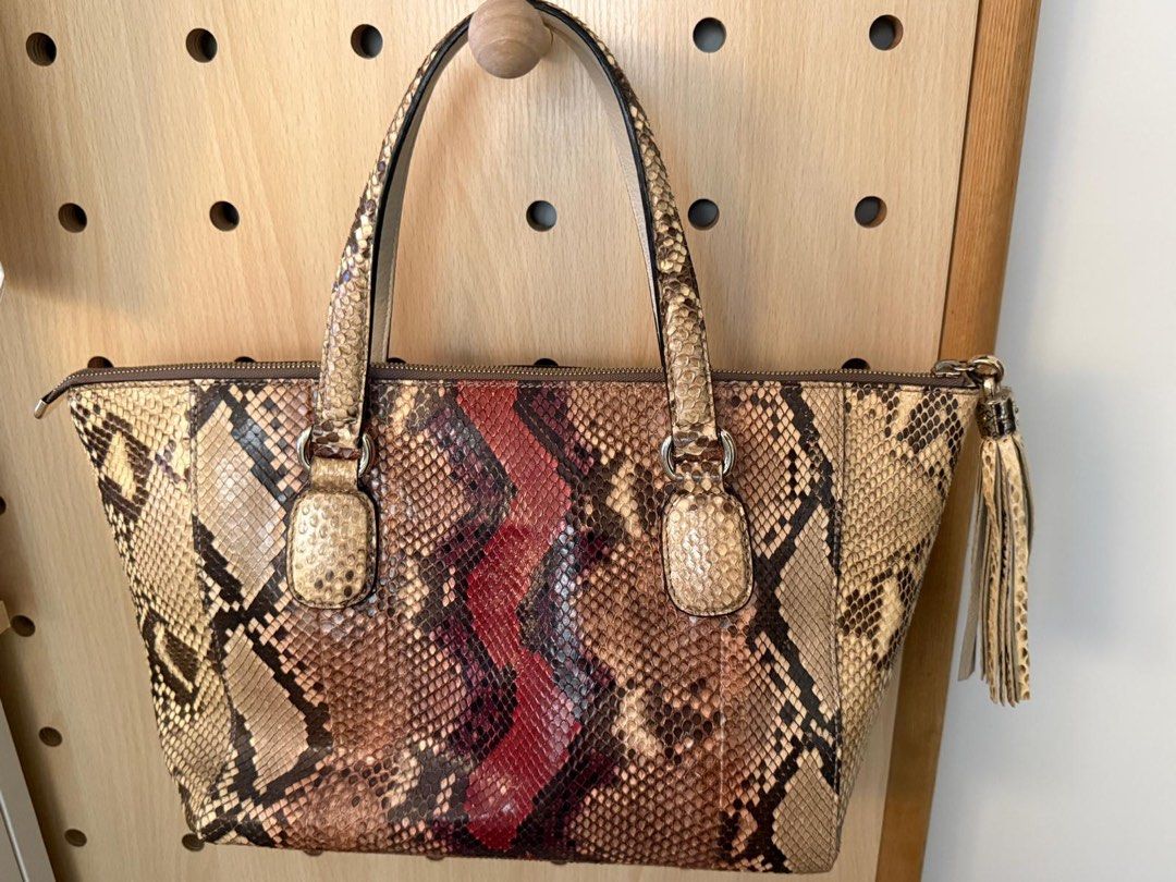Authentic Gucci Python Leather bag （分類：手袋及銀包）位於 Hong Kong。 由 clevercrystal14 提交（商品編號 1451675758，圖片 2）。簡介： 100% authentic Gucci Python Leather Handbag Featured a python leather body and leather tassel details ( brand sticker is still on ) flat leather straps, an open top, and interior zip and slip pockets. Conditon : As pictured. Used < 5 times. Material Python Leather Dimensions Open top : 42cm Base : 30cm Height : 24cm Width : 12cm Sold as it. N