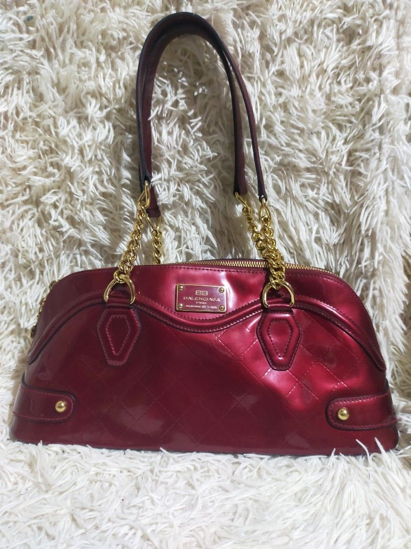Balenciaga patent quilted (Category: Luxury Bags & Wallets) located in Manila. Submitted by darleng.d228ef (Listing ID 1451683545, Image 1). Description: This is a vintage Balenciaga patent quilted chain shoulder bag, identified by its glossy red finish and gold-tone chain strap. Brand: Balenciaga Material: Quilted patent leather (enamel) Key Features: Gold-tone chain shoulder strap and a front metal logo plate Era: Estimated to be from the mid-2