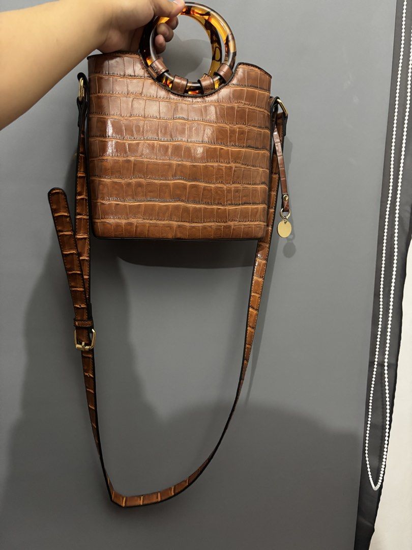 Brown Croc Embossed Top Handle Bag with Tortoiseshell Handle (Category: Luxury Bags & Wallets) located in Olongapo. Submitted by lovejeansph (Listing ID 1451559582, Image 2). Description: - Stylish brown bag with a sophisticated croc-embossed texture. - Features a unique tortoiseshell top handle. - Includes a long, adjustable strap for versatile crossbody or shoulder wear. - Accented with elegant gold hardware details on the side. - Ideal for bot