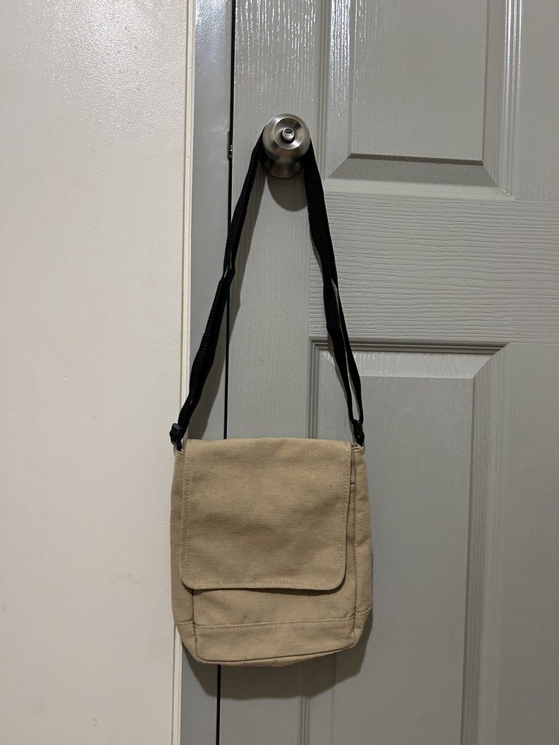 Canvas Crossbody Bag with Black Strap (Category: Looking For) located in Manila. Submitted by declutteringmpc (Listing ID 1451688541, Image 1). Description: - Beige canvas crossbody bag - Black adjustable strap - Secure flap closure - Black panel on the back - Ideal size for everyday essentials - Easy and convenient to carry.