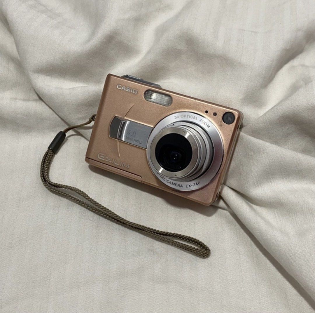 Casio EXILIM EX-Z40 Digital Camera - Rose Gold (Category: Cameras) located in Quezon City. Submitted by no.hain4 (Listing ID 1451628354, Image 1). Description: - Casio EXILIM digital camera - Rose gold color - 7.0 megapixel resolution - 3x optical zoom - Screen has visible scratches - Powers on and functions correctly - Comes with a wrist strap - Ideal for everyday, casual photography.