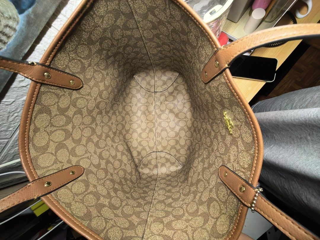 Coach Brown Monogram Reversible Tote Bag (Category: Luxury Bags & Wallets) located in Manila. Submitted by khasseyfinds (Listing ID 1451633781, Image 3). Description: - Classic Coach tote bag - Color: Brown - Signature monogram print inside - Leather trim and handles - Spacious interior, ideal for everyday use - Tag attached - Condition: Good, with minor signs of use only no flaws .