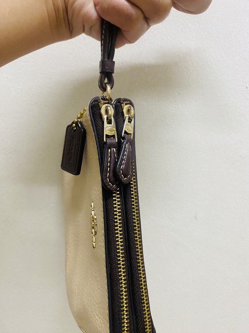 Coach Leather Wristlet Beige Brown Double Zip (Category: Luxury Bags & Wallets) located in Manila. Submitted by TindahanNiLhelay (Listing ID 1451641630, Image 2). Description: - Coach wristlet in beige and brown textured leather. - Two zippered compartments for secure storage. - Includes a dark brown leather hang tag. - Detachable wrist strap for convenience. - Made in Myanmar. - Serial number: N°H2223 91622..
