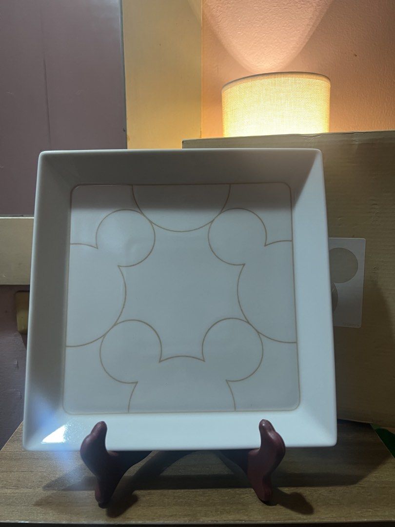 Disney Mickey Mouse Square Serving Platter with Box (Category: Dinnerware & Cutlery) located in Pasig City. Submitted by allaboutstuff.co (Listing ID 1451619388, Image 2). Description: - Square serving platter with subtle Mickey Mouse ear pattern - Made in Japan - Includes original box - Dimensions: Approx. 9 x 9 inches - Ideal for serving snacks or as a decorative piece - A must-have for Disney enthusiasts!.