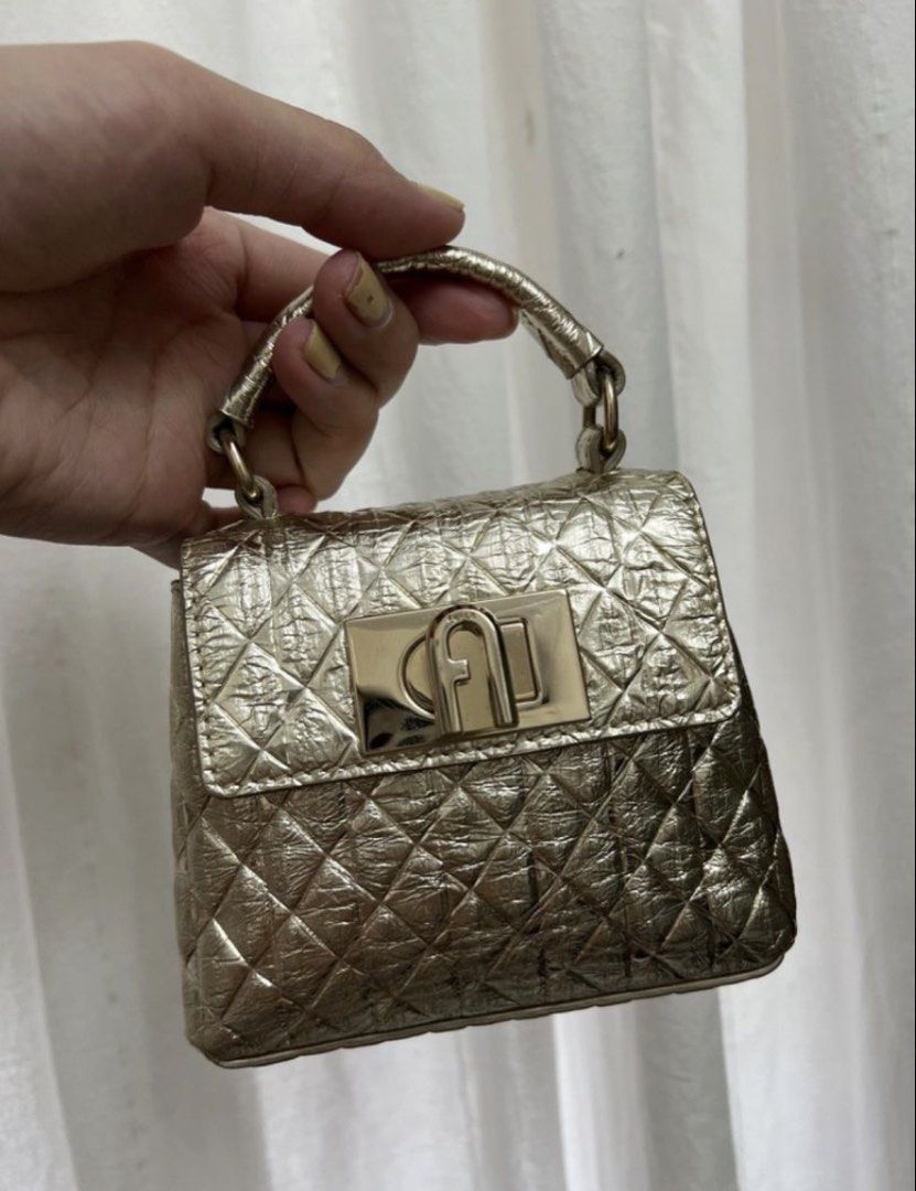 Furla Mini Quilted Metallic Gold Handbag (Category: Luxury Bags & Wallets) located in Taguig. Submitted by cftbncs (Listing ID 1451598886, Image 1). Description: - Super cute mini bag - Metallic gold color with quilted pattern - Turn-lock closure - Comes with a long strap - Ideal for nights out or adding a pop of shine - Small and compact.