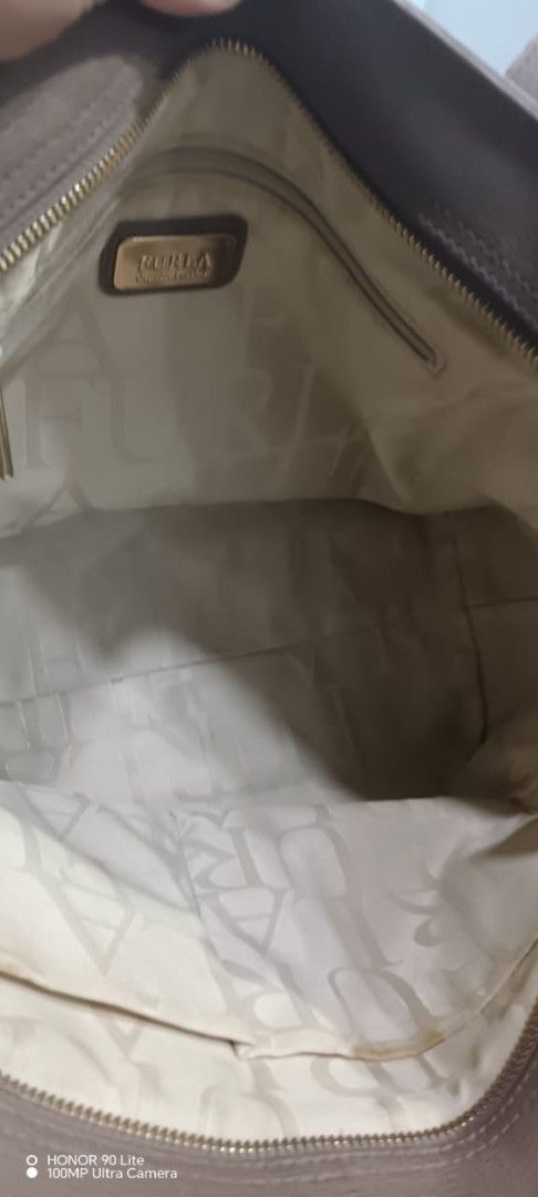 Furla Tote Bag Beige Leather (Category: Tote Bags) located in Kuala Kurau. Submitted by fiverose86 (Listing ID 1451646695, Image 3). Description: - Beige Furla tote bag - Spacious interior - Zippered top closure - Lined with Furla logo pattern - Fits a laptop - Ideal for everyday use or work.