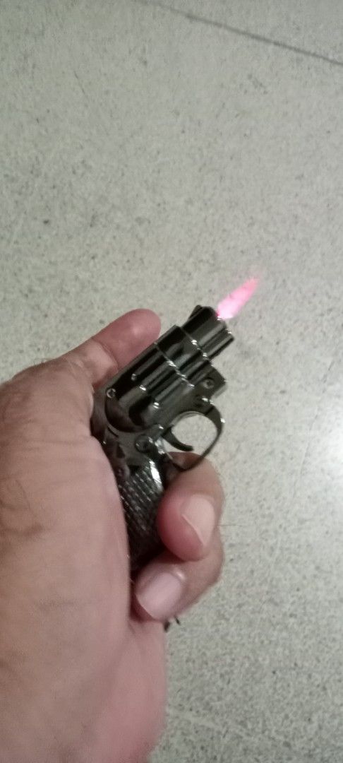 Gun Shaped Lighter Keychain (Category: Craft Supplies & Tools) located in Taytay. Submitted by joselaquino (Listing ID 1451695924, Image 2). Description: - Unique mini revolver shaped lighter - Doubles as a keychain for portability - Lights up with a cool pink flame - Durable metal body, feels solid - Refillable for long-term use - Perfect conversation starter and gift idea.