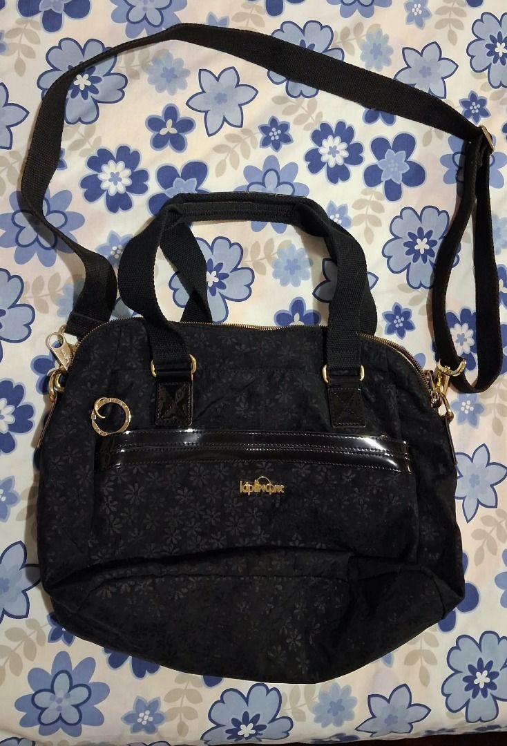 Kipling Black Floral Print Shoulder Bag (Category: Shoulder Bags) located in Quezon City. Submitted by jac20 (Listing ID 1451691751, Image 1). Description: - Stylish black Kipling bag with a subtle floral pattern. - Versatile carrying options: top handles and a detachable shoulder strap. - Elegant gold hardware details. - Practical interior zip pocket for secure storage. - Spacious enough to hold all your daily essentials. - Perfect for everyday 
