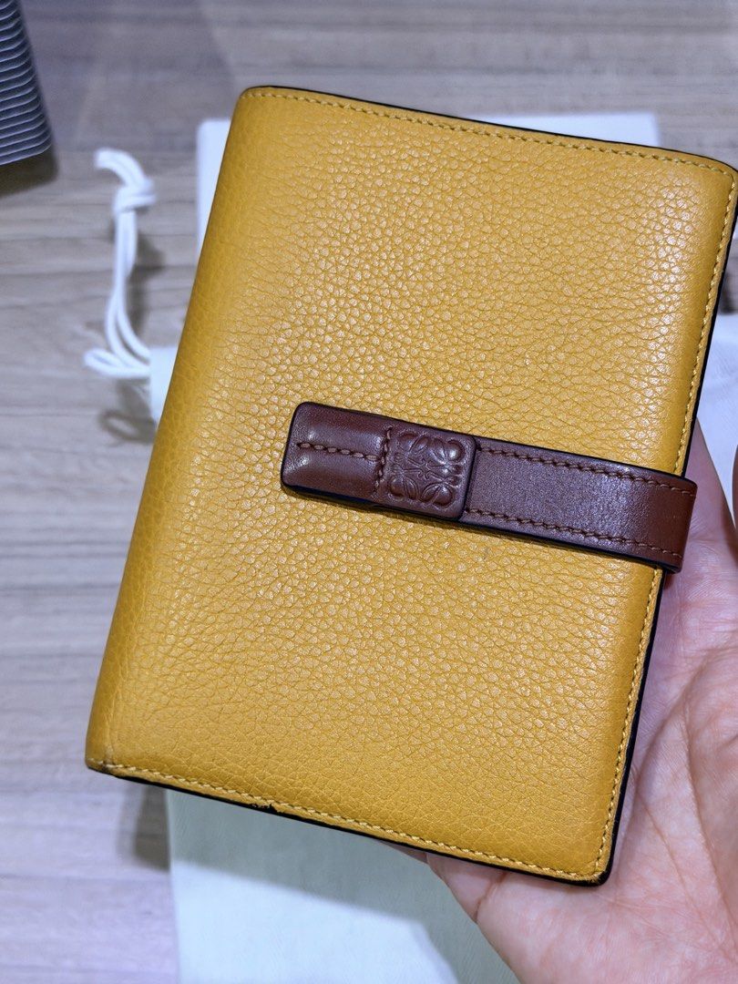 LOEWE Leather Bi-fold Wallet Yellow (Category: Luxury Bags & Wallets) located in Pasig City. Submitted by theclosetcasemanila (Listing ID 1451614266, Image 2). Description: - Guaranteed Authentic - LOEWE bi-fold wallet with strap - Pebbled leather. Mustard yellow. - Brown leather strap with Anagram logo - Multiple interior card slots - Interior zip pocket - Includes dust bag and box - Clean. No flaws or damages. - Made in Spain Includes box and d