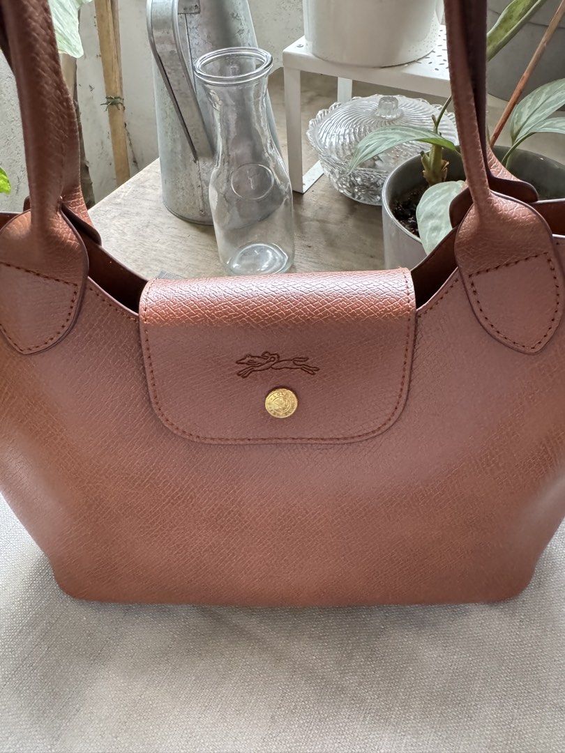 Longchamp Le Pliage Cuir Leather Handbag (Category: Luxury Bags & Wallets) located in Muntinlupa City. Submitted by felma31 (Listing ID 1451608372, Image 1). Description: - Genuine brown leather Longchamp handbag - Iconic embossed logo on the front flap - Two comfortable top handles - Ample interior space for all your essentials - Ideal for everyday use - Meticulously cleaned and well-maintained.