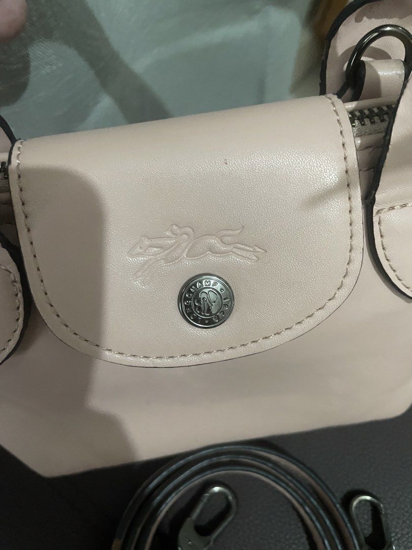 Longchamp Le Pliage Cuir Top Handle Bag (Category: Luxury Bags & Wallets) located in Manila. Submitted by misyeli (Listing ID 1451588446, Image 3). Description: - Authentic Longchamp handbag - Chic light pink color - Genuine leather material - Features a top handle and a detachable shoulder strap - Secure zipper closure - Compact, small size, ideal for everyday essentials.