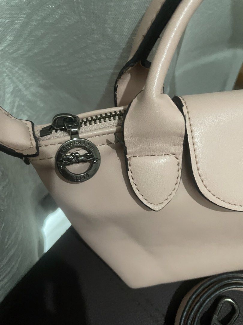 Longchamp Le Pliage Cuir Top Handle Bag (Category: Luxury Bags & Wallets) located in Manila. Submitted by misyeli (Listing ID 1451588446, Image 2). Description: - Authentic Longchamp handbag - Chic light pink color - Genuine leather material - Features a top handle and a detachable shoulder strap - Secure zipper closure - Compact, small size, ideal for everyday essentials.