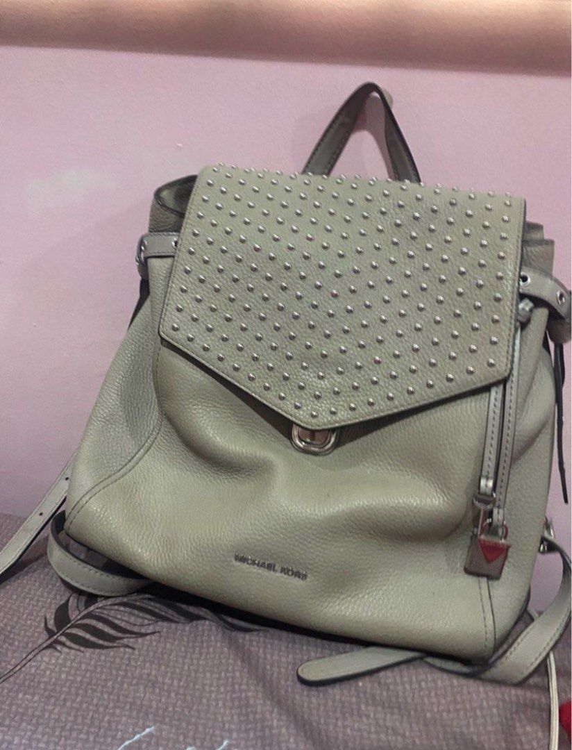 Michael Kors Studded Leather Backpack Grey (Category: Backpacks) located in Manila. Submitted by _andireya (Listing ID 1451696624, Image 1). Description: - Michael Kors Grey Leather Backpack - Features silver stud detailing on the flap - Secure turn-lock closure - Includes a small padlock charm - Adjustable shoulder straps for comfort - Ideal for everyday use.