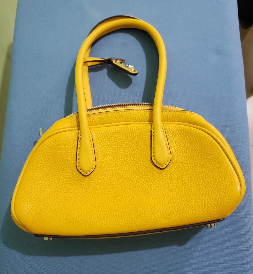 Michael Kors Yellow Leather Satchel Handbag (Category: Luxury Bags & Wallets) located in Navotas City. Submitted by miloklo (Listing ID 1451600010, Image 2). Description: - Bright yellow Michael Kors handbag - Textured pebble leather finish - Iconic MK logo charm - Secure zipper closure - Protective metal feet on the bottom - Ideal size for everyday essentials - Clean and well-maintained .