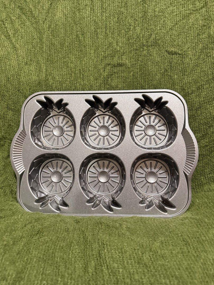 Nordic Ware Pineapple Upside Down Mini Cake Pan (Category: Bakeware) located in Manila. Submitted by georgethjafine (Listing ID 1451687074, Image 1). Description: - Brand: Nordic Ware - Design: Pineapple Upside Down Mini Cake Pan - Makes 6 individual pineapple-shaped cakes - Durable construction for even baking - Perfect for desserts and parties.