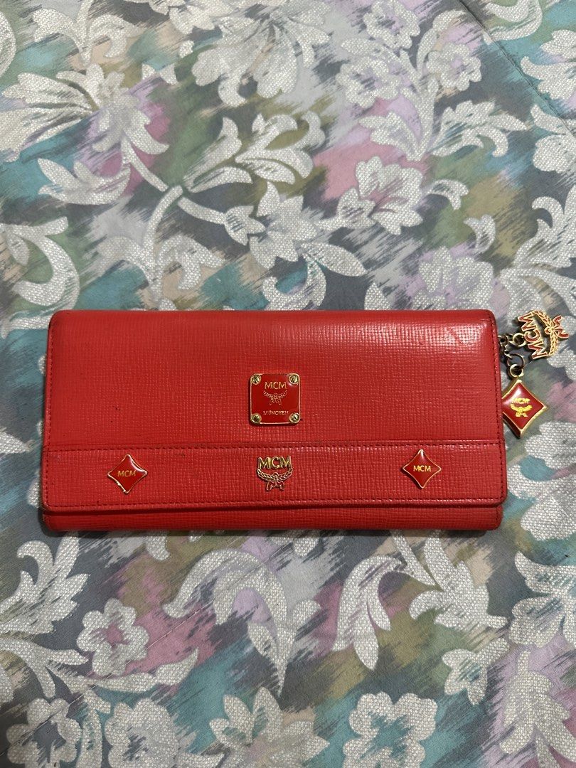 ORIGINAL MCM Red Leather Long Wallet with Charms (Category: Luxury Bags & Wallets) located in Naga. Submitted by bag.net (Listing ID 1451649367, Image 1). Description: - Authentic red MCM long wallet(money back 💯 guaranteed if fake) - Genuine leather with signature MCM logo details - Adorable MCM charms attached - Ample card slots and compartments for organization - Includes a secure zipper pocket -stunning in actual🥰.