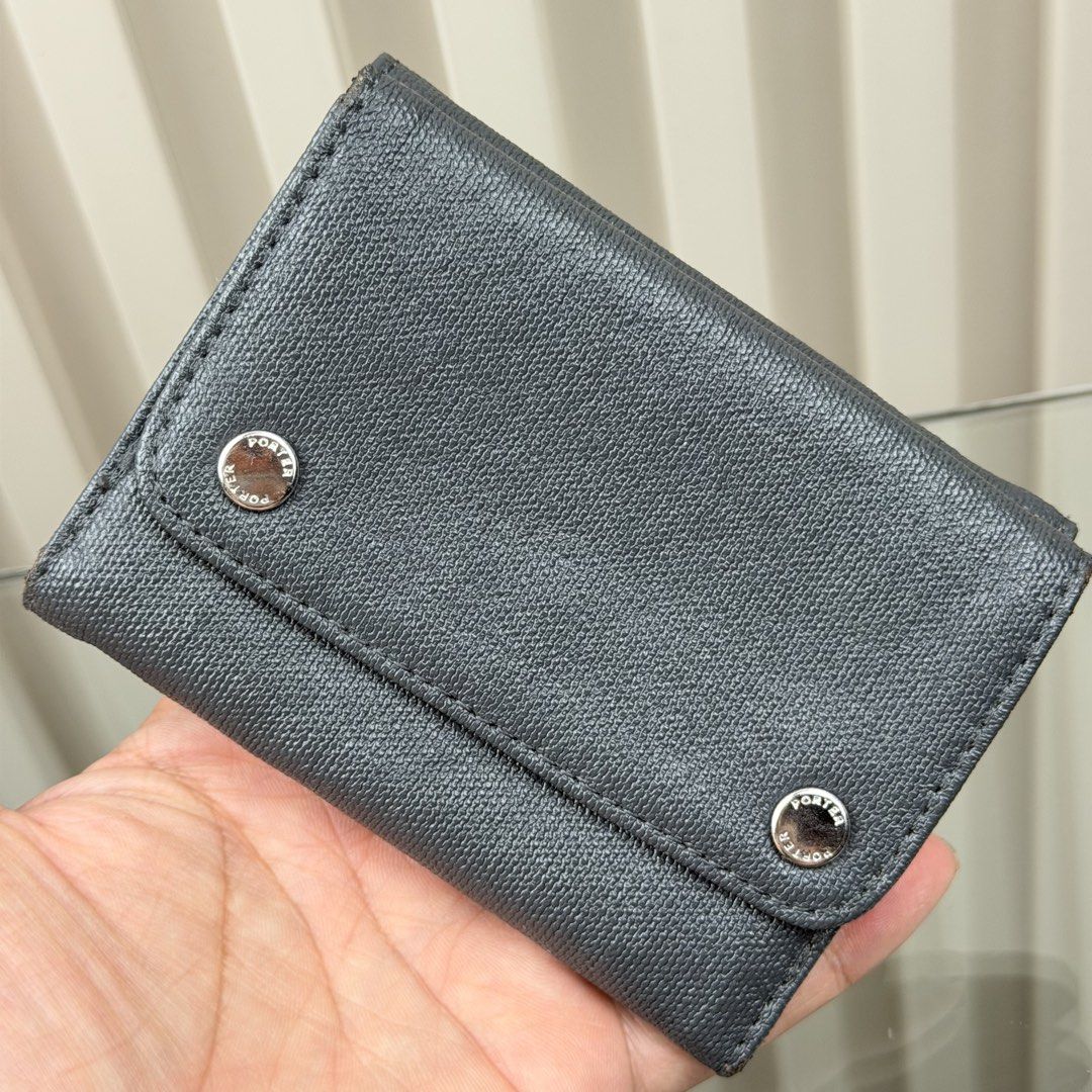 Porter International Tri-fold Wallet (Category: Wallets & Card Holders) located in Pasig City. Submitted by trendapparelph (Listing ID 1451591333, Image 3). Description: - Porter International tri-fold wallet - Dark blue/grey textured material - Features a coin compartment and card slots - Secure snap button closure - Small metal logo plate on the front - Clean interior - Perfect for everyday use.