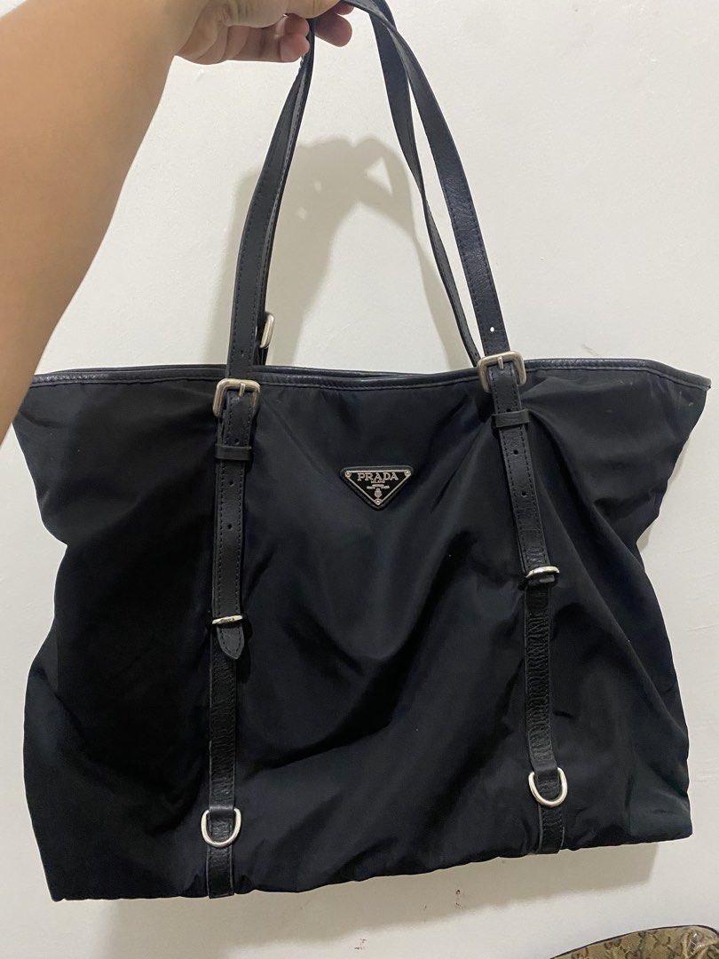 Prada Black Nylon Leather Trim Tote Bag (Category: Luxury Bags & Wallets) located in Paete. Submitted by ladder_leynn (Listing ID 1451646863, Image 1). Description: - Prada Tote Bag - Color: Black - Material: Nylon with Leather Trim and Straps - Hardware: Silver - Interior: Zippered pocket and Prada logo lining - Style: Spacious and practical for everyday use - A timeless Prada classic -AUTH NOT GUARANTEED.
