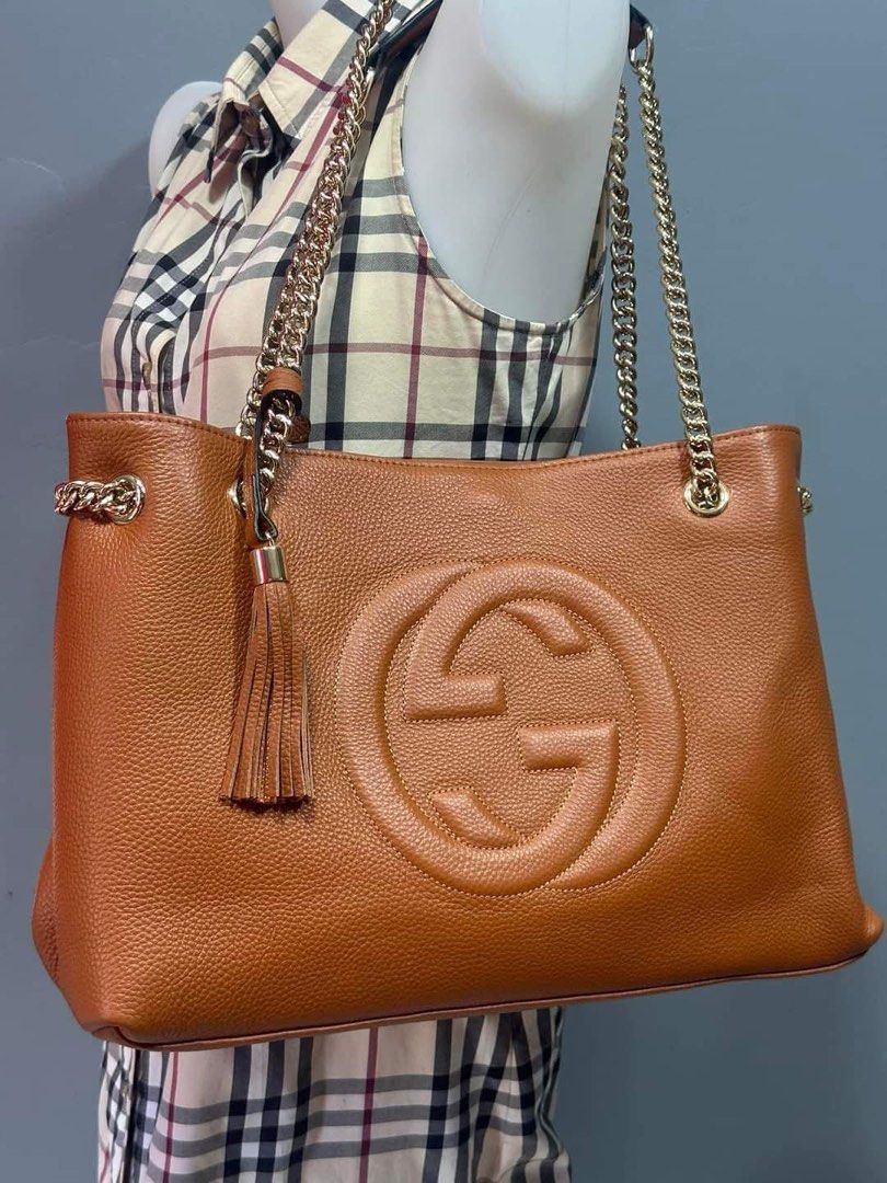 Preloved gutzzzii soho leather chain tote (Category: Luxury Bags & Wallets) located in Los Banos. Submitted by ditasbautista2329 (Listing ID 1451663633, Image 1). Description: Premium pebbled leather • Iconic embossed GG logo • Gold-tone chain shoulder straps • Leather tassel accent • Spacious interior • Color: Cognac/Tan Brown • Elegant at versatile design.