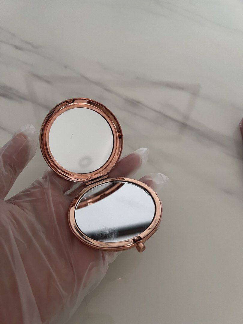Rose Gold Round Compact Mirror (Category: Mirrors) located in Manila. Submitted by lilac.z (Listing ID 1451672739, Image 2). Description: - Elegant rose gold compact mirror - Features two mirrors inside - Compact and portable for easy carrying - Ideal for quick touch-ups anywhere - Classic and simple design - Fits perfectly in purses or pockets.