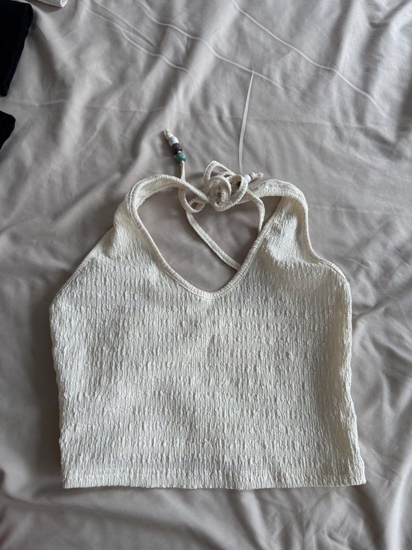 SHEINCream Textured Halter Neck Crop Top with Beaded Straps (Category: Sleeveless) located in Manila. Submitted by reicroque (Listing ID 1451644663, Image 1). Description: - Cream textured halter neck crop top - Ties at the back of the neck - Features cute beaded detail on the straps - Estimated size: S or M - Ideal for summer or beach vacation - Versatile styling with shorts or skirts.