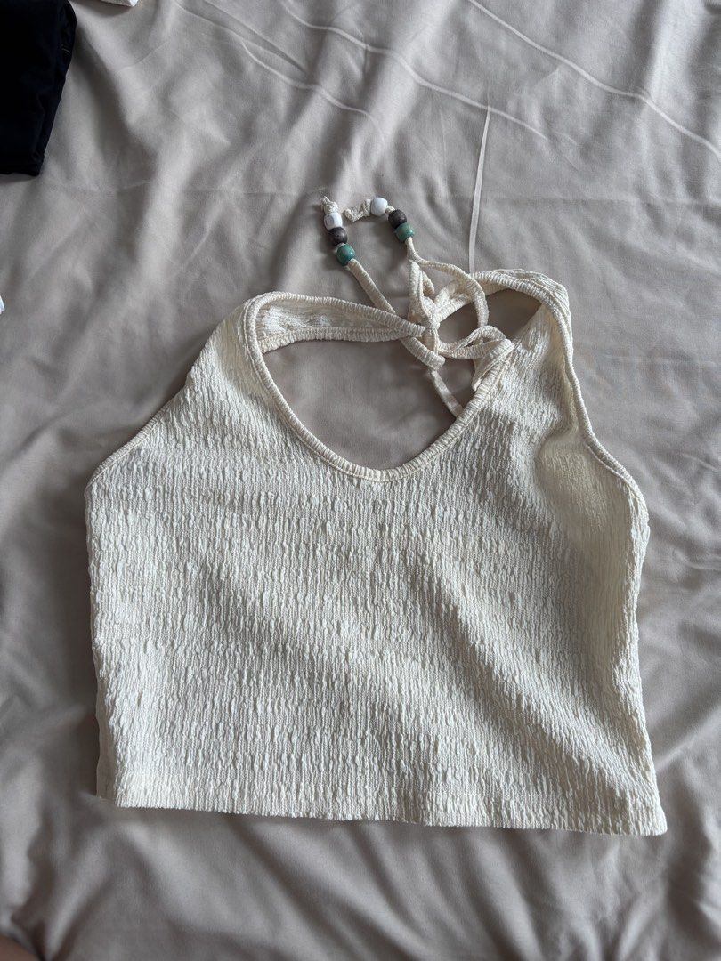 SHEINCream Textured Halter Neck Crop Top with Beaded Straps (Category: Sleeveless) located in Manila. Submitted by reicroque (Listing ID 1451644663, Image 2). Description: - Cream textured halter neck crop top - Ties at the back of the neck - Features cute beaded detail on the straps - Estimated size: S or M - Ideal for summer or beach vacation - Versatile styling with shorts or skirts.