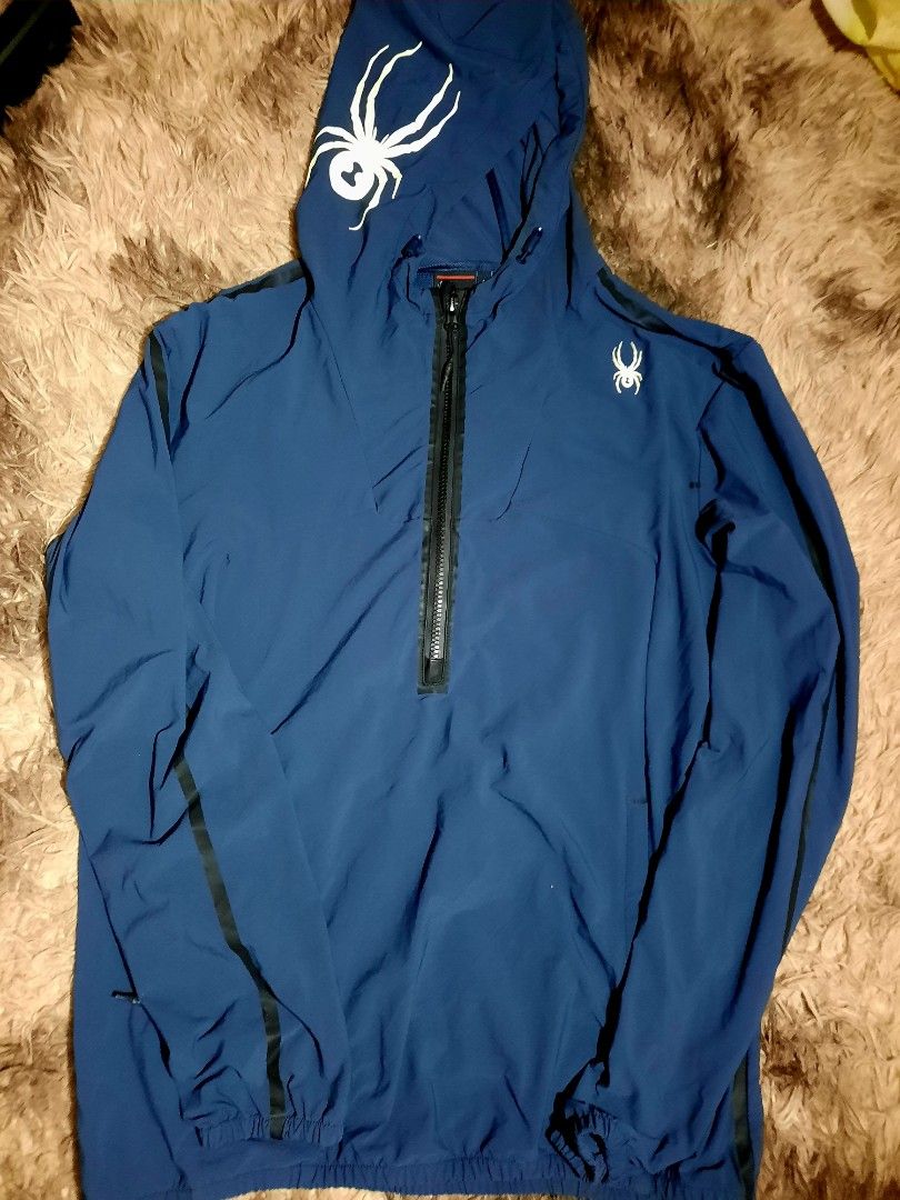 Spyder Navy Blue Anorak Jacket with Spider Logo (Category: Coats, Jackets and Outerwear) located in Lapu Lapu. Submitted by markbel26 (Listing ID 1451559963, Image 1). Description: - Navy blue Spyder anorak jacket - Iconic spider logo on hood and chest - Half-zip closure - Kangaroo pocket - Black stripe detail down the sleeves - Elasticated cuffs and hem - Ideal for outdoor activities or casual wear.