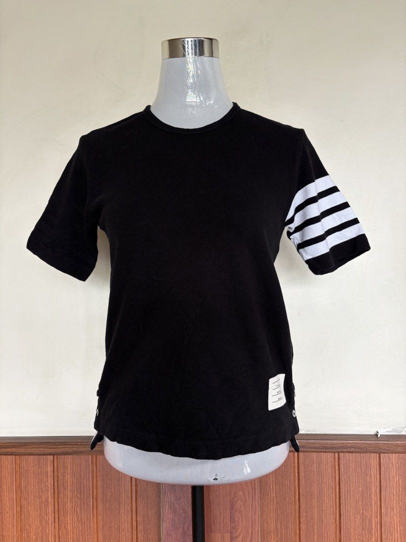 Thom Browne Black Textured Knitted T-shirt Top (Category: Luxury Apparel) located in Cebu City. Submitted by stylingtrends.coll (Listing ID 1451531925, Image 1). Description: - Black🖤 - Shortsleeves - Premium textured knitted - Classic 4 bar stripe Size: Small-Med.