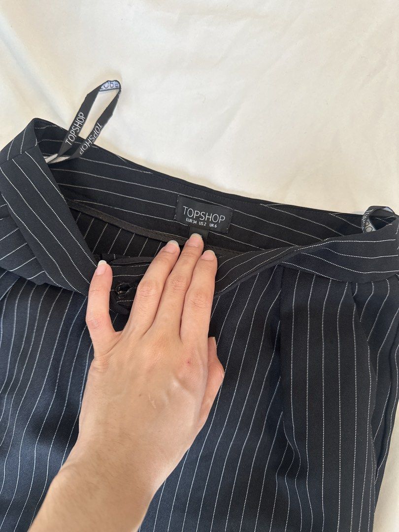 TOPSHOP Black Pinstripe Trousers (Category: Other Bottoms) located in Makati City. Submitted by marcheu (Listing ID 1451602365, Image 2). Description: - Classic black trousers with subtle white pinstripes. - Flattering high-waisted design. - Secure button and zip closure. - Versatile straight-leg cut. - Effortlessly pairs with blouses, tees, or sweaters for work or casual looks..