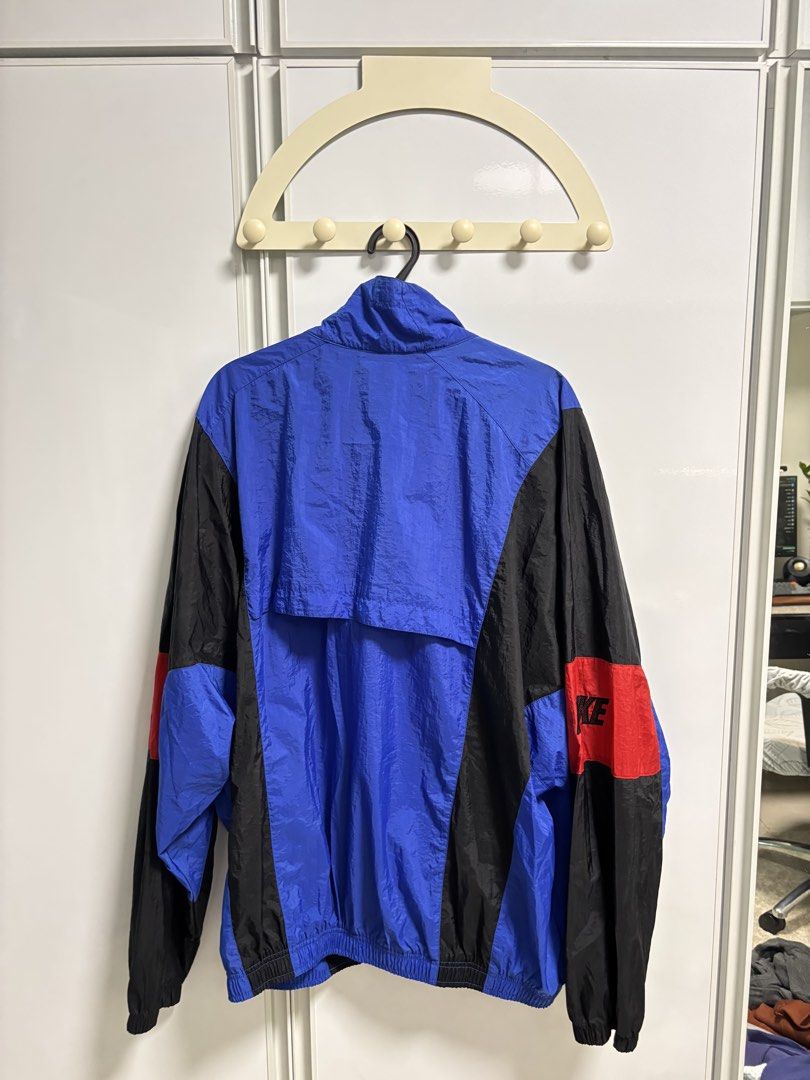 Vintage Nike Windbreaker Jacket Blue Black Red (Category: Coats, Jackets and Outerwear) located in San Fernando. Submitted by blique2018 (Listing ID 1451654673, Image 2). Description: - Classic Nike windbreaker - Bold blue, black, and red color block design - Lightweight material, perfect for layering - Iconic Nike swoosh on chest and logo on sleeve - Full zip closure - Elastic cuffs and hem - Size: XL - Dimes: 27.5 x 27.5 - Condition: 8/10; ink 