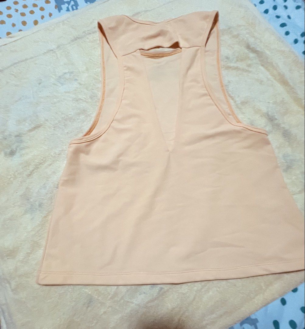 Yellow Cut Out Back Tank Top (Category: Sleeveless) located in Antipolo. Submitted by murapod2 (Listing ID 1451528653, Image 1). Description: - Peach colored tank top - Sleeveless design - Unique back cut-out detail - Relaxed fit for comfort - Perfect for workouts or casual outings - Made with soft, breathable fabric.
