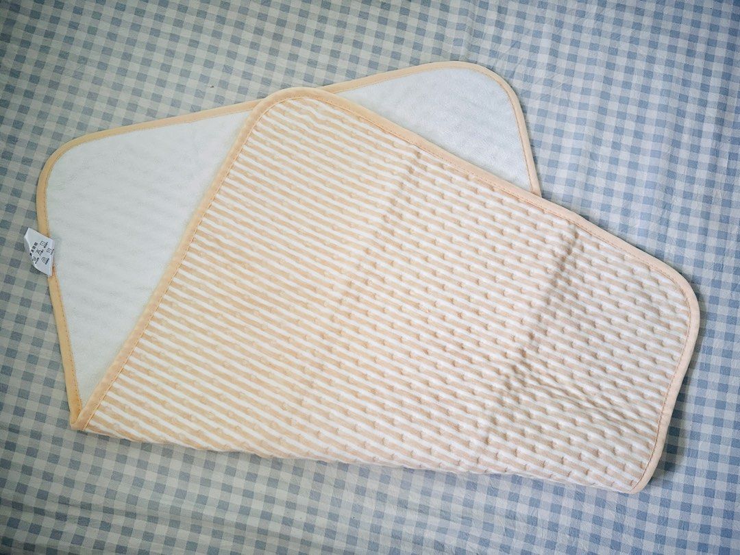 Baby Changing Mat - Soft & Absorbent (Category: Changing Mats & Accessories) located in Taguig. Submitted by lizzzzzx (Listing ID 1451703046, Image 1). Description: - Soft and absorbent material for baby's comfort. - Reversible design: one side striped, the other plain white. - Edges are neatly trimmed with soft binding. - Ideal for convenient diaper changes at home or while traveling. - Easy to clean and maintain. - Provides a comfortable surfac