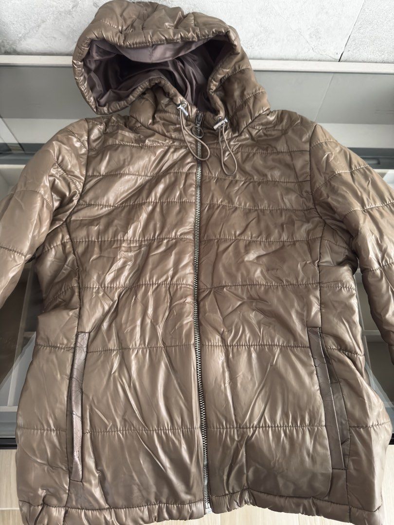 Bershka Brown Puffer Jacket with Hood (Category: Coats, Jackets and Outerwear) located in Makati City. Submitted by tinkerboy (Listing ID 1451708249, Image 1). Description: - Bershka brown puffer jacket - Features a hood with drawstrings - Zip-up front closure - Convenient side pockets - Made with a shiny material - Ideal for cooler weather - Versatile and easy to style.