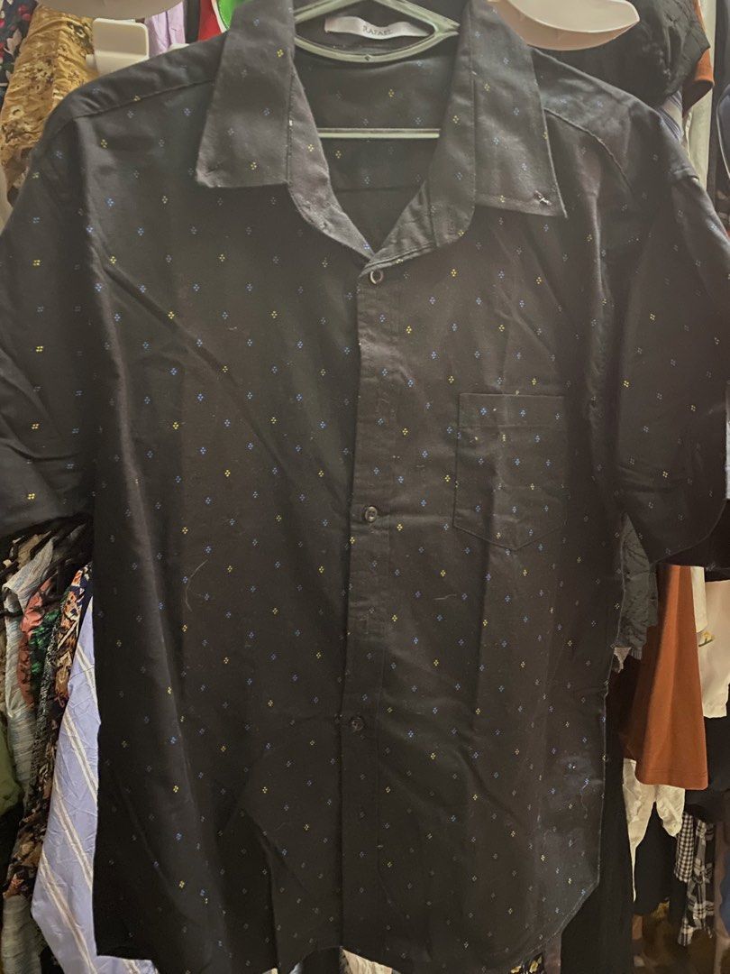 Black Short Sleeve Button Up Shirt with Diamond Pattern (Category: Tshirts & Polo Shirts ) located in Bauang. Submitted by nrrandomthings (Listing ID 1451702549, Image 2). Description: - Black short sleeve button-up shirt - Features a small diamond pattern in yellow and blue - Single chest pocket - Classic collar - Versatile for casual or slightly dressed-up occasions.