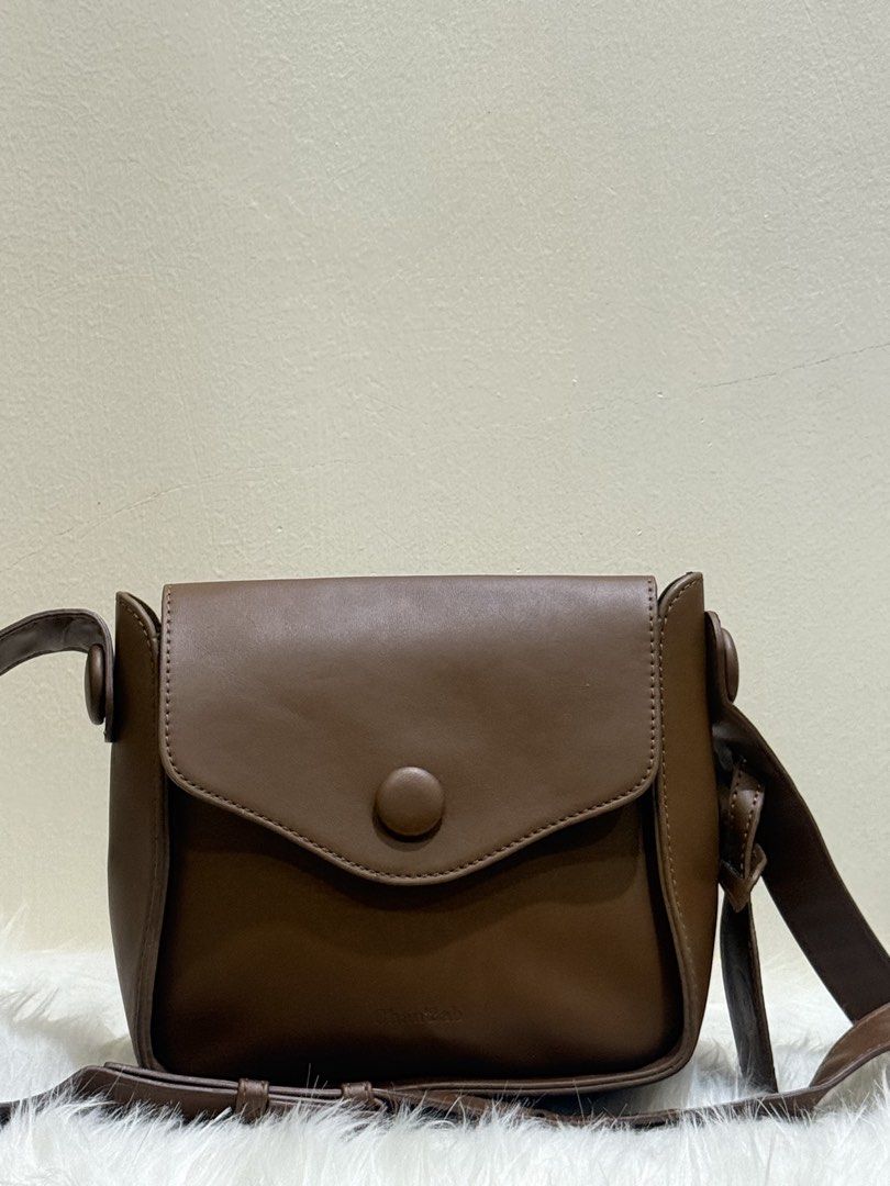Tan Brown Flap Shoulder Crossbody Bag (Category: Cross-body Bags) located in Quezon City. Submitted by clazzystudio (Listing ID 1451846409, Image 1). Description: Selling this chic tan brown crossbody bag featuring a smooth faux leather finish, clean contrast edge coating, and stylish top hardware accents. It features a fold-over flap closure and a long adjustable shoulder strap. Perfect for adding a warm, classic, and minimalist touch to your da