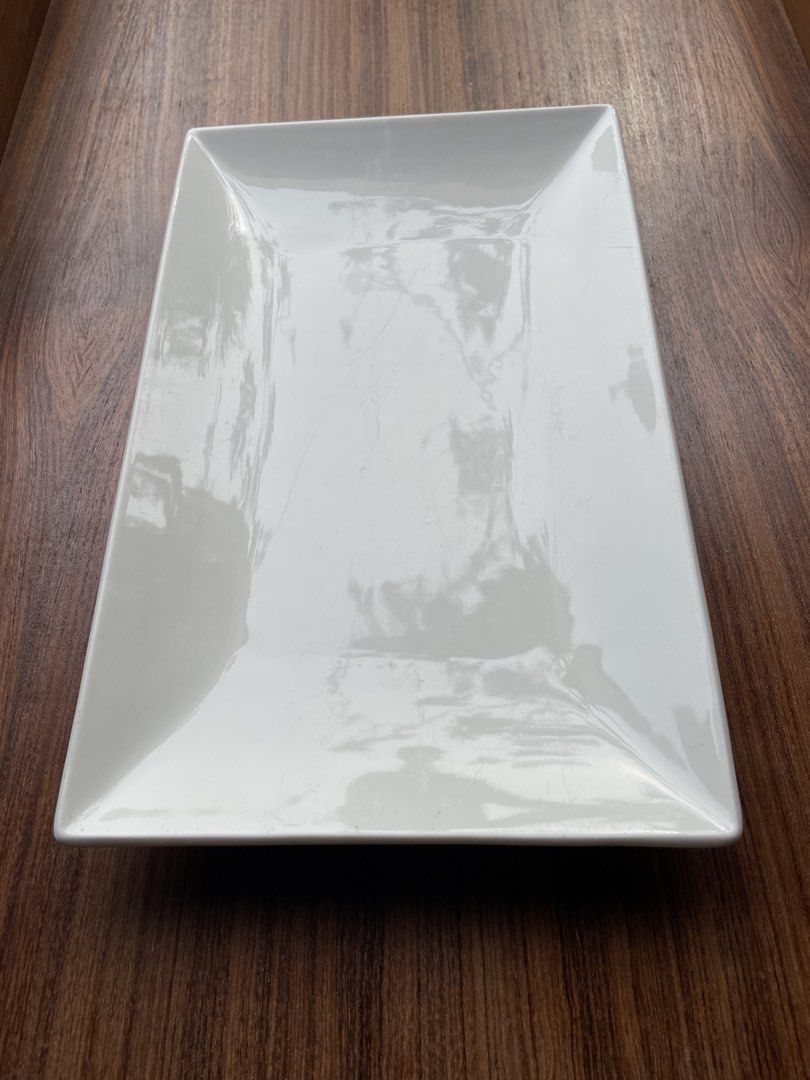 Ceramics Essentials Rectangular Serving Platter White (Category: Dinnerware & Cutlery) located in Singapore. Submitted by goodman1063 (Listing ID 1451793387, Image 1). Description: - White rectangular serving platter - Brand: Ceramica Essentials - Ideal for appetizers, sushi, or small bites - Shows light surface scratches from normal use - Clean and ready for its new home.