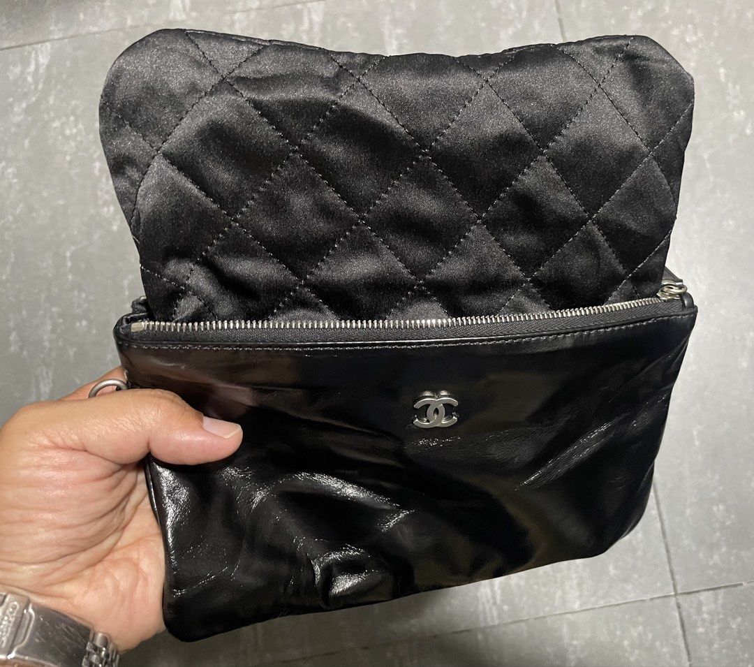 Chanel Shiny Calfskin Pouch (Category: Luxury Bags & Wallets) located in Calapan. Submitted by lucasthrifts (Listing ID 1451805560, Image 3). Description: - Black patent leather pouch - Quilted satin lining - Silver zipper closure with Chanel logo detail - Ideal for organizing essentials or as a standalone clutch - Clean inside and out.