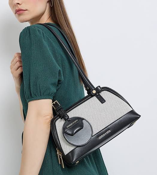 Charles & Keith ENOLA SHOULDER BAG (Category: Shoulder Bags) located in Las Pinas. Submitted by cattydeclutters (Listing ID 1451792807, Image 2). Description: - Cute shoulder bag from Charles & Keith - Material: Mix of canvas and black leather - Features a decorative round charm - Adjustable strap for comfortable wear - with dust bag - bought for 4,599.