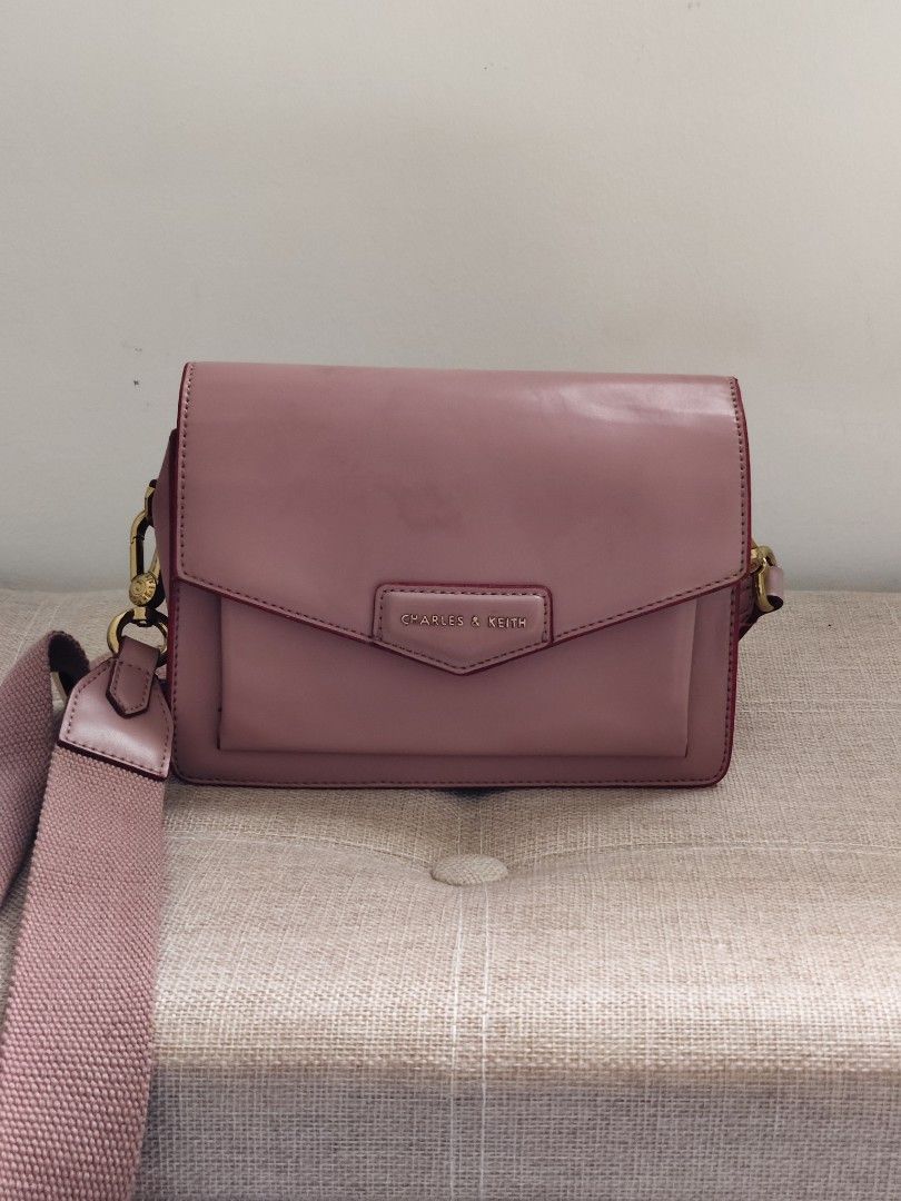 Charles & Keith Pink Crossbody Bag (Category: Cross-body Bags) located in Davao. Submitted by wangcollections (Listing ID 1451882020, Image 1). Description: - OG Charles & Keith (thrifted) -Looks like mall pullout and never been used -Just flaws inside the bag, leather has cracks already kaya mura nalang pero hindi halata since nasa loob -Outside still looks very good -Glittery rubber lining so cute - Adjustable and removable strap - Elegant gold