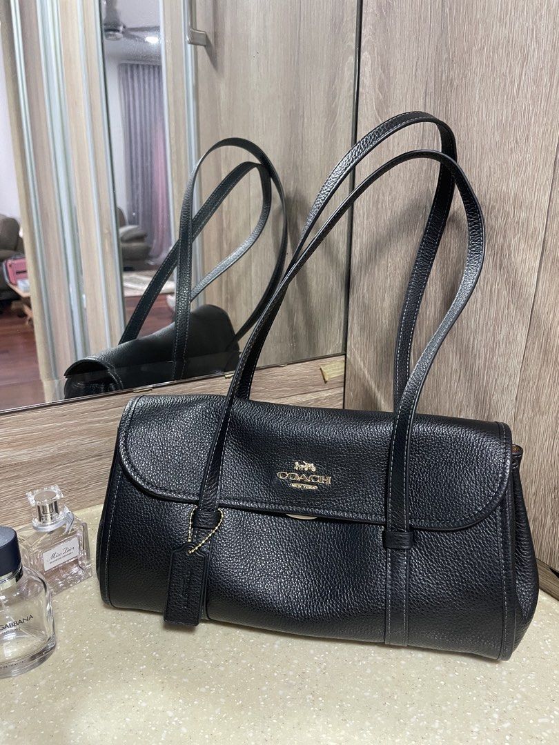 Coach Bridget Flap Shoulder Bag (Category: Bags & Wallets) located in Kuala Lumpur. Submitted by belleohbells (Listing ID 1451783021, Image 1). Description: - Genuine black pebbled leather Coach shoulder bag - Luxurious tan suede-like interior lining - Spacious main compartment - Internal zip pocket for secure storage - Elegant flap closure with a classic turn-lock - Comfortable shoulder straps for easy carrying - Ideal for everyday use and versa