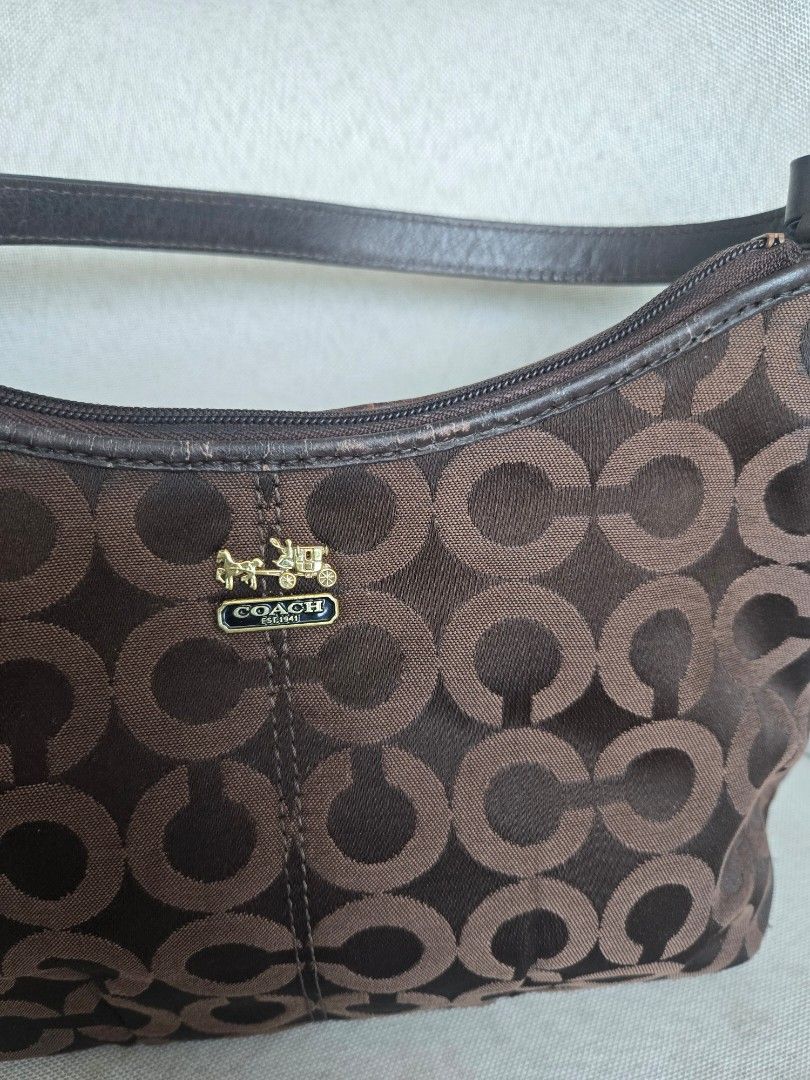 Coach Monogram Hobo Bag Brown (Category: Luxury Bags & Wallets) located in Manila. Submitted by shla.dln (Listing ID 1451711687, Image 3). Description: - Authentic brown Coach hobo bag - Signature monogram pattern - Genuine leather trim and strap - Elegant gold hardware - Secure zipper closure - Shows minor signs of wear on leather strap and hardware.