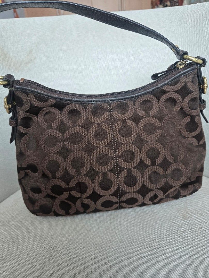 Coach Monogram Hobo Bag Brown (Category: Luxury Bags & Wallets) located in Manila. Submitted by shla.dln (Listing ID 1451711687, Image 2). Description: - Authentic brown Coach hobo bag - Signature monogram pattern - Genuine leather trim and strap - Elegant gold hardware - Secure zipper closure - Shows minor signs of wear on leather strap and hardware.