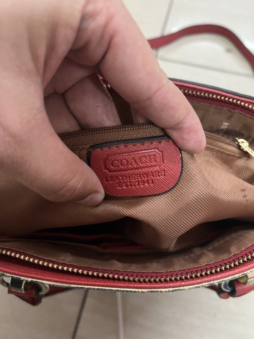 Coach Signature Monogram Satchel Red Trim (Category: Luxury Bags & Wallets) located in Bulacan. Submitted by sef19 (Listing ID 1451781593, Image 2). Description: - Authentic Coach monogram satchel bag - Color: Tan with signature C pattern - Trim and handles: Red leather - Hardware: Gold details - Includes: Long adjustable strap - Origin: Made in Vietnam - Interior: Coach leather patch.