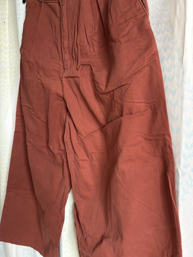EARTH Wide Leg Cropped Pants - Rust Color (Category: Other Bottoms) located in Adams. Submitted by eggs.sam.cheese (Listing ID 1451806742, Image 3). Description: - Rust colored wide leg cropped pants - High waisted with front pleats - Two back pockets - Sturdy cotton blend fabric - Versatile for casual or dressed-up outfits - Easy to style with various tops and shoes.