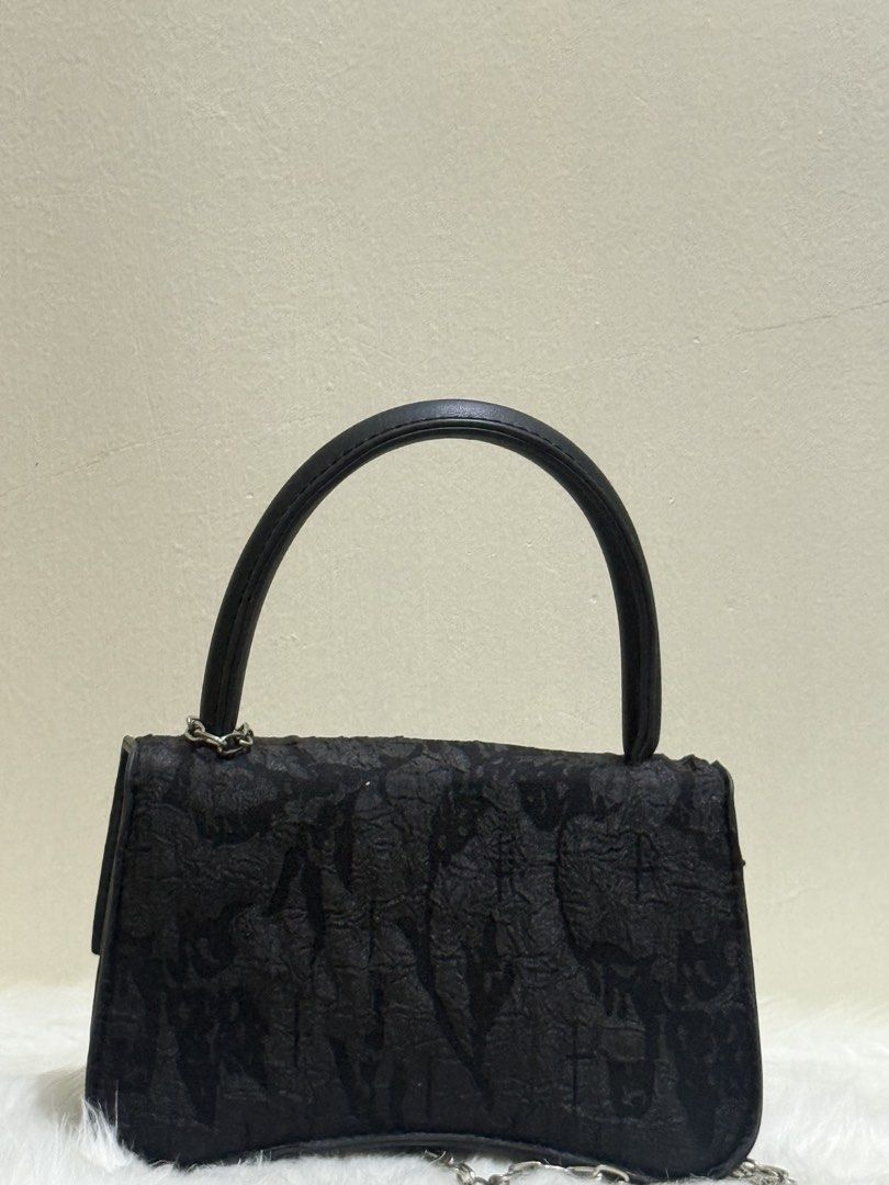Black Textured Butterfly Flap Mini Top Handle Handbag (Category: Purses & Pouches) located in Quezon City. Submitted by clazzystudio (Listing ID 1451849753, Image 3). Description: Selling this chic black mini handbag featuring a unique crinkled textured flap, silver butterfly center emblem, and a dangling heart and pearl charm accent. It features a top rounded handle, fold-over flap closure, and a delicate silver chain shoulder strap. Perfect for