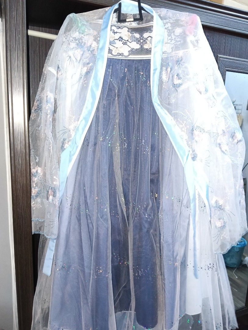 Hanfu Blue Chinese Traditional Dress Outfit Pretty (Category: Traditional & Ethnic wear) located in Merbok. Submitted by littlejeon (Listing ID 1451761304, Image 1). Description: - Beautiful blue dress with a delicate sheer, embroidered overlay. - Overlay features intricate floral patterns and scattered glitter for a magical touch. - Designed with thin straps and a flowing skirt for an elegant silhouette. - Made from light and airy fabric, perfec
