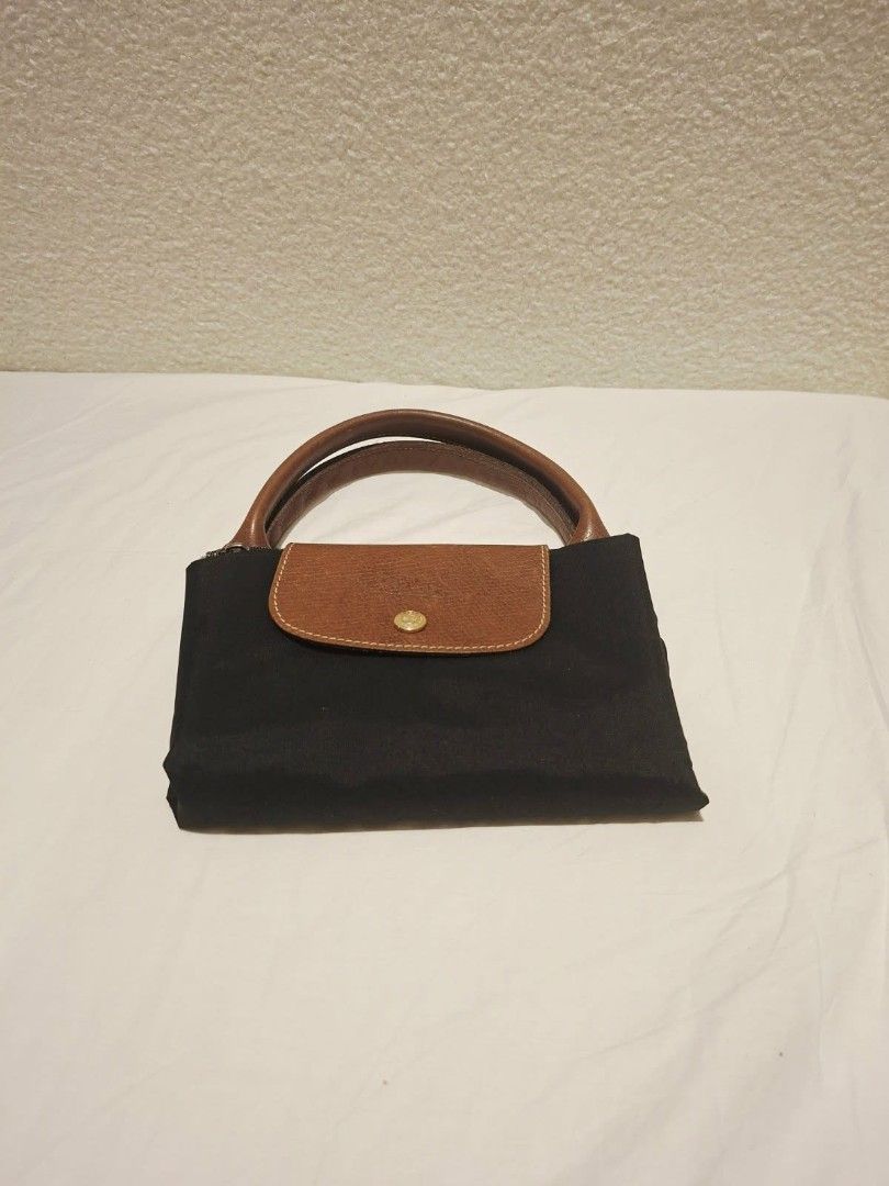 Longchamp Le Pliage Cuir Small Top Handle Bag Black (Category: Luxury Bags & Wallets) located in Makati City. Submitted by jacky222323 (Listing ID 1451824157, Image 2). Description: - Classic Longchamp bag in black - Small/Medium size, ideal for daily essentials - Made with durable nylon and leather trim - Features top zip closure with a snap-button flap - Comfortable leather handles - Folds flat for convenient storage - Versatile for any occasio