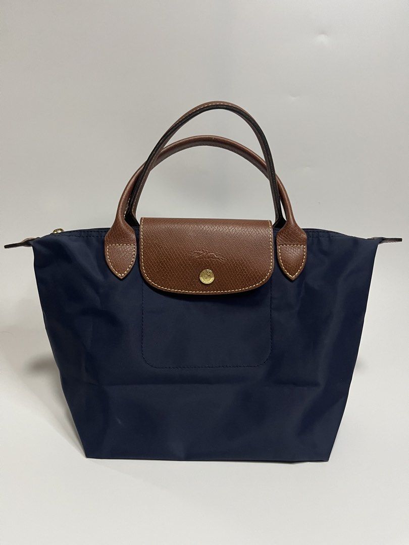 Longchamp Le Pliage Neo Top Handle Bag Navy Blue (Category: Luxury Bags & Wallets) located in Manila. Submitted by niandv (Listing ID 1451851630, Image 1). Description: - Navy blue Longchamp Le Pliage Neo bag - Medium size - Genuine leather handles and trim - Elegant gold hardware - Secure zipper closure with snap button flap - Ideal for everyday use - Ample interior space.