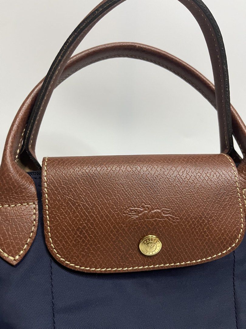 Longchamp Le Pliage Neo Top Handle Bag Navy Blue (Category: Luxury Bags & Wallets) located in Manila. Submitted by niandv (Listing ID 1451851630, Image 3). Description: - Navy blue Longchamp Le Pliage Neo bag - Medium size - Genuine leather handles and trim - Elegant gold hardware - Secure zipper closure with snap button flap - Ideal for everyday use - Ample interior space.